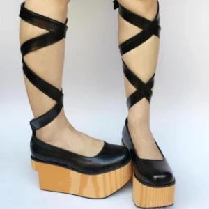 Black matte round-toe platform lolita bridal shoes with detachable crisscross calf straps worn on model legs front view
