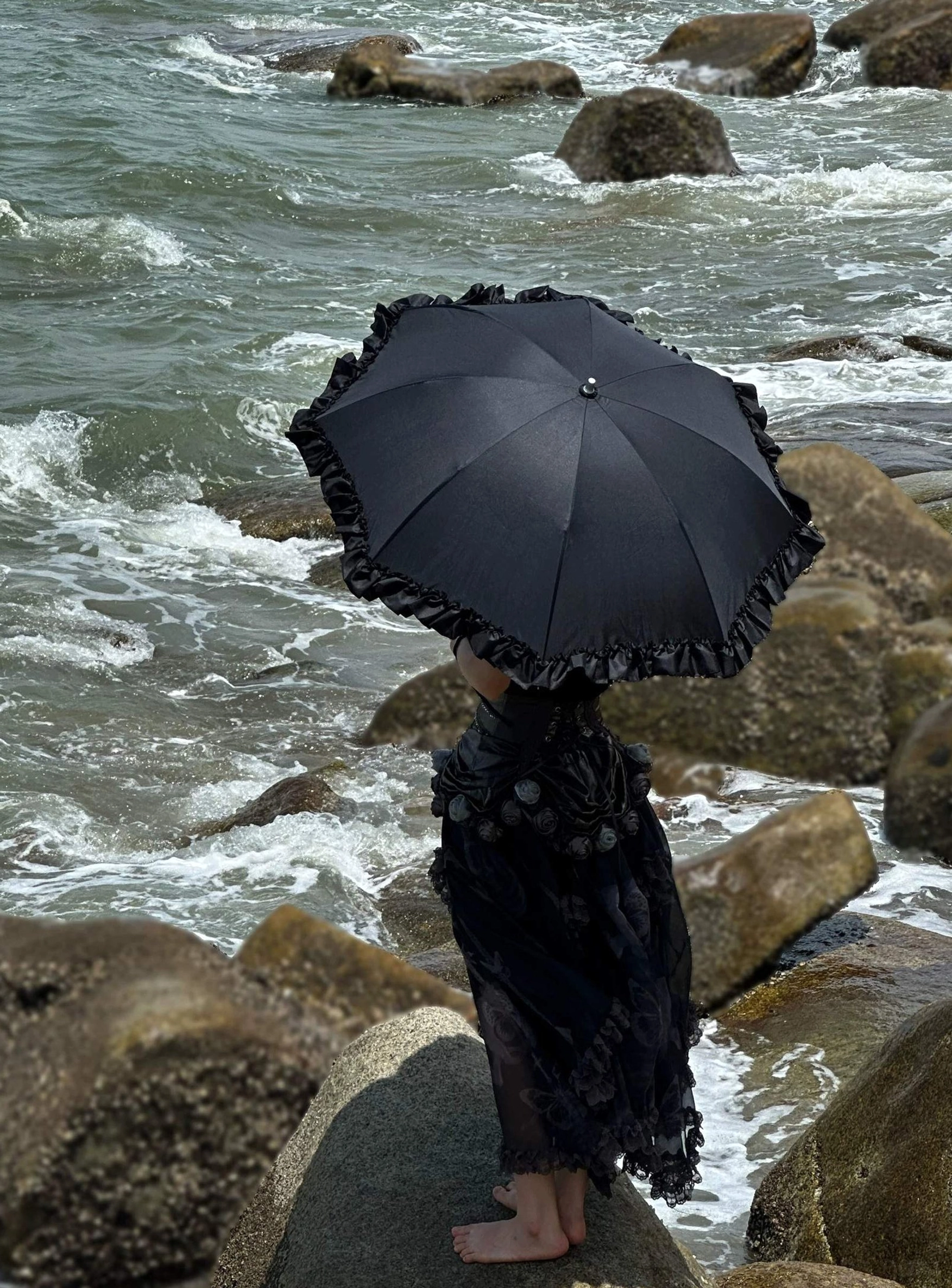 Black multi-layer ruffled Lolita parasol with cascading dimensional frill embellishments creating sculptural silhouette, overhead flat lay capturing layered design details