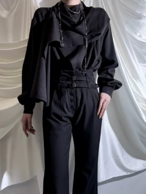 Front full-body ouji lolita menswear set in all-black featuring asymmetric layered cowl collar, double buckle waist cincher, layered chain necklace accessory styling on male model
