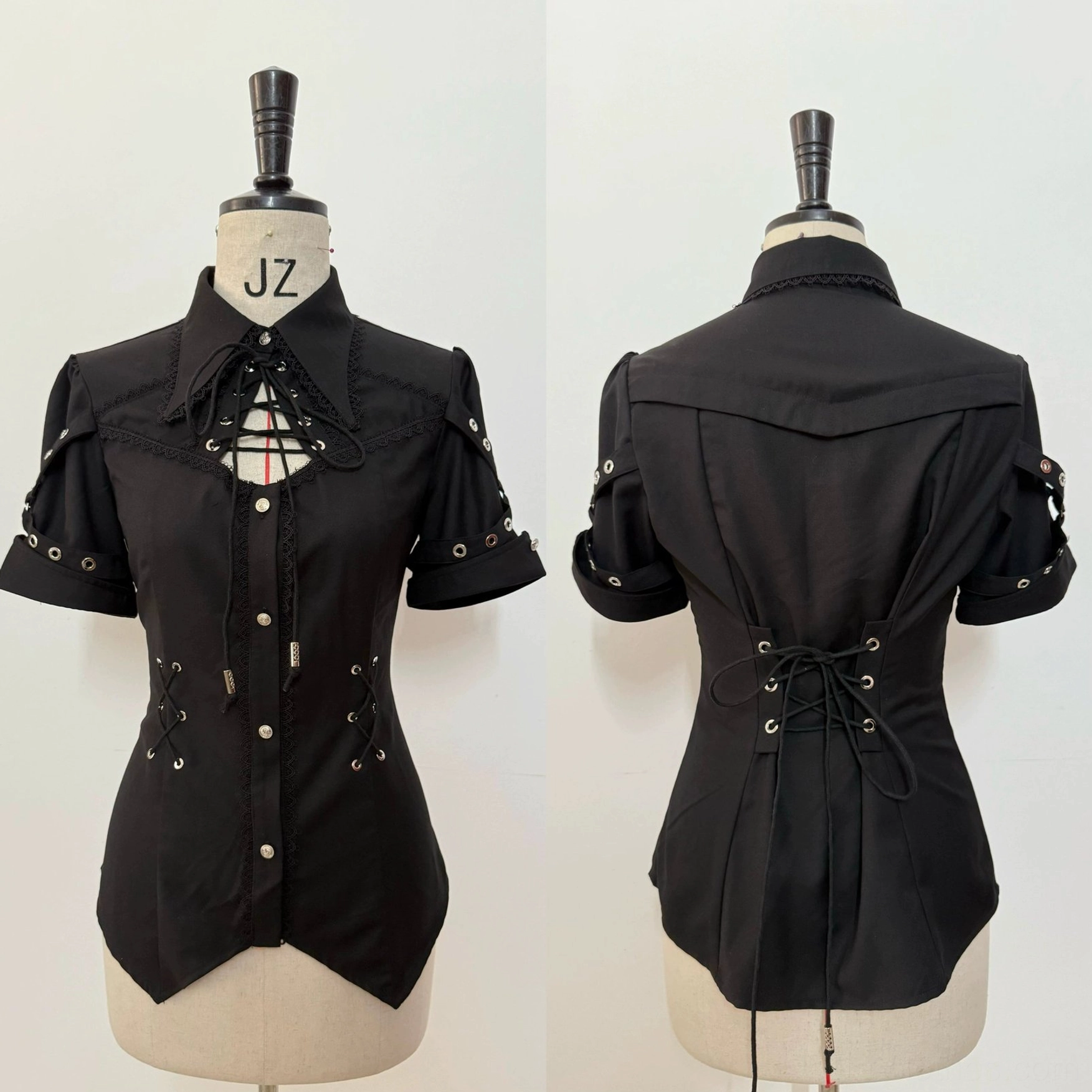 Black Ouji Lolita blouse front and back dual mannequin display showing front chest cutout with lace-up closure, buttoned front, back waist corset lace-up detail, decorative sleeve hardware, pointed shirt hem and prince-style collar