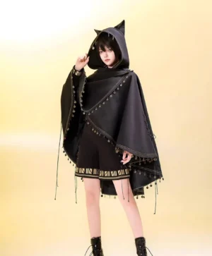 Model wearing black cat ear lolita cape with gold trim over black shorts full body front standing view