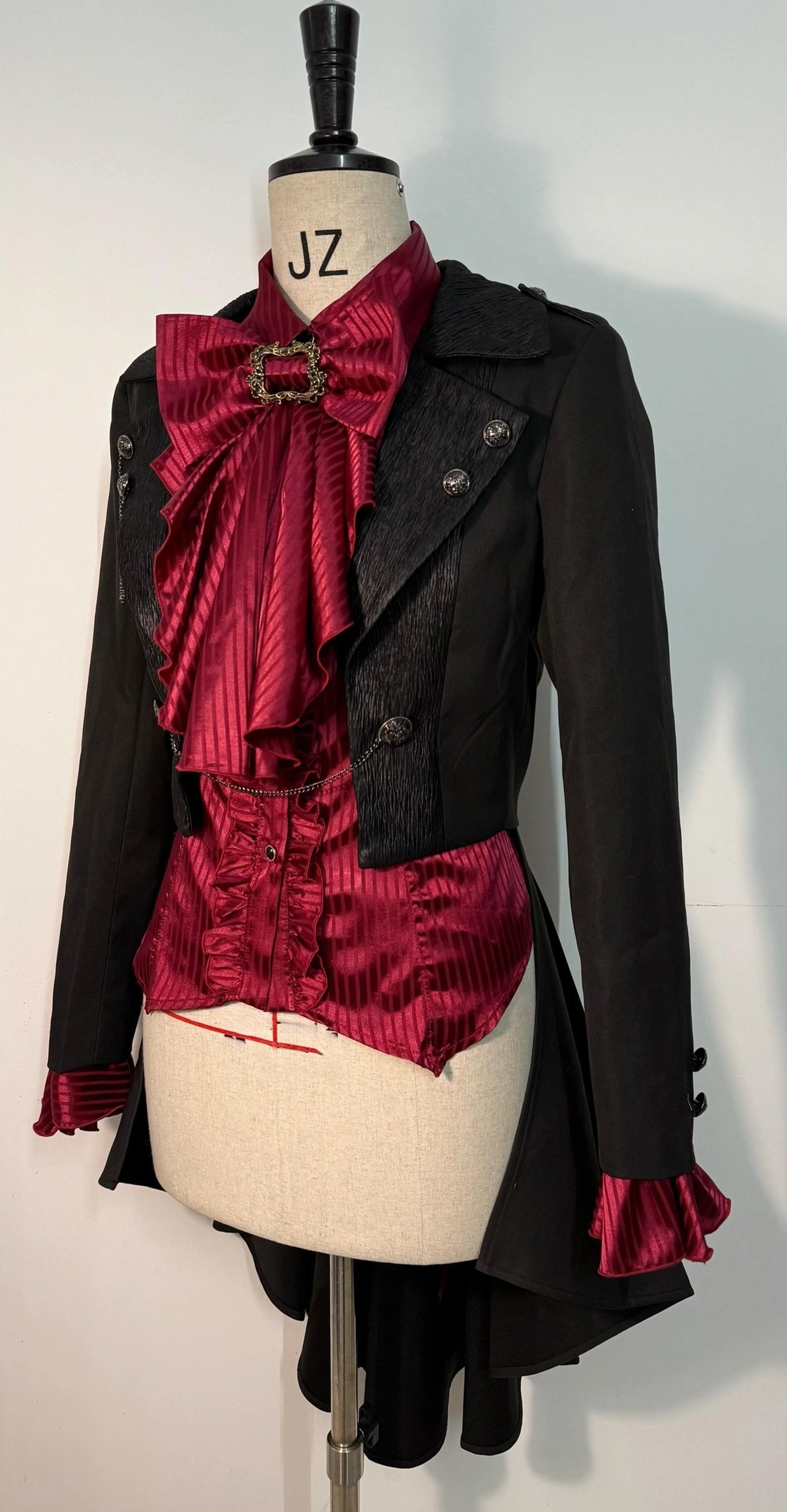 Black Ouji Lolita open front coat with detachable metal chain decoration displayed on dress form, front-facing studio view showing blazer-style lapel and fitted waist silhouette