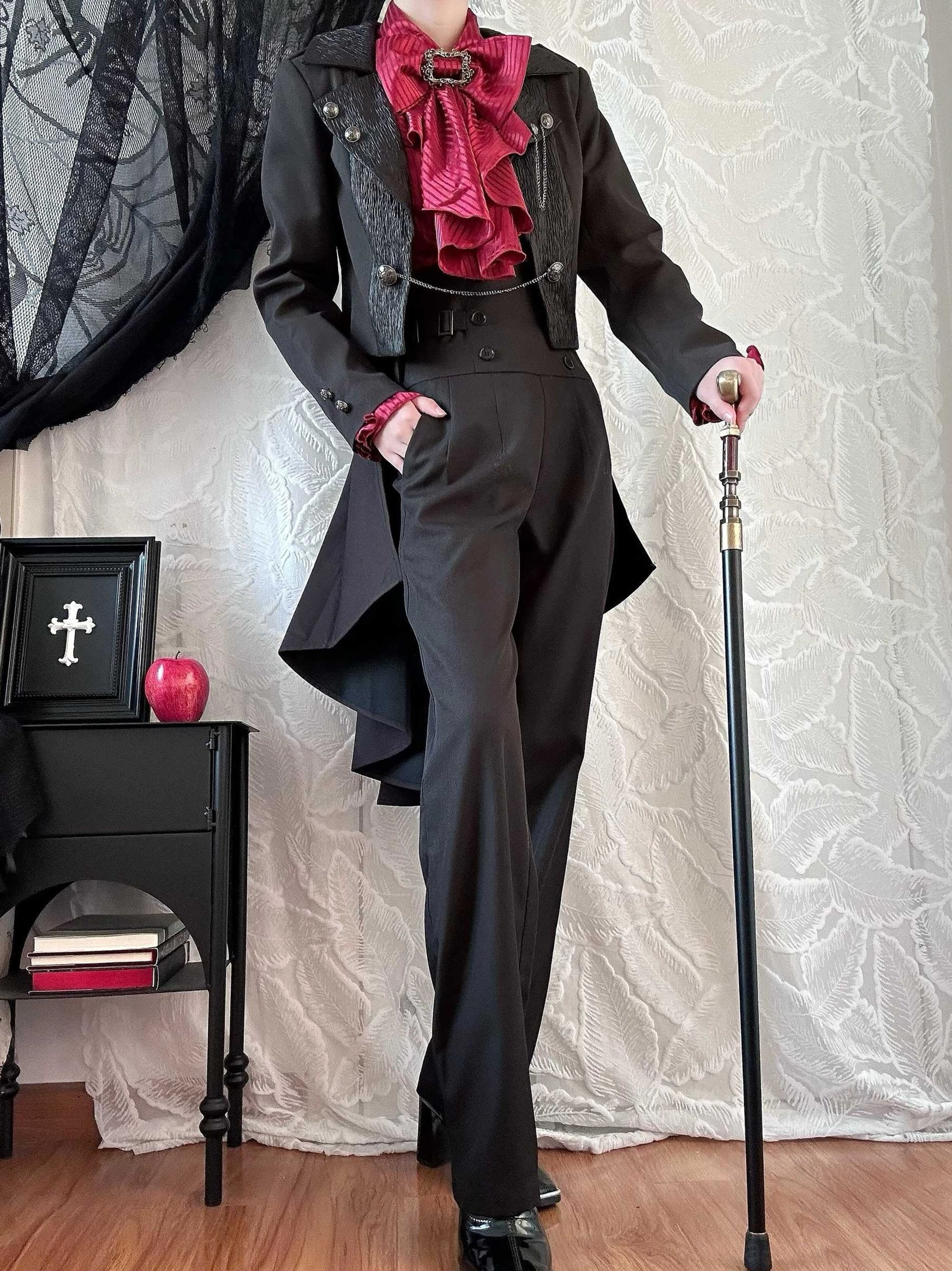 Full-body side profile view of black Ouji Lolita coat ensemble worn with coordinating gothic accessories, showing elegant trailing hemline and aristocratic silhouette