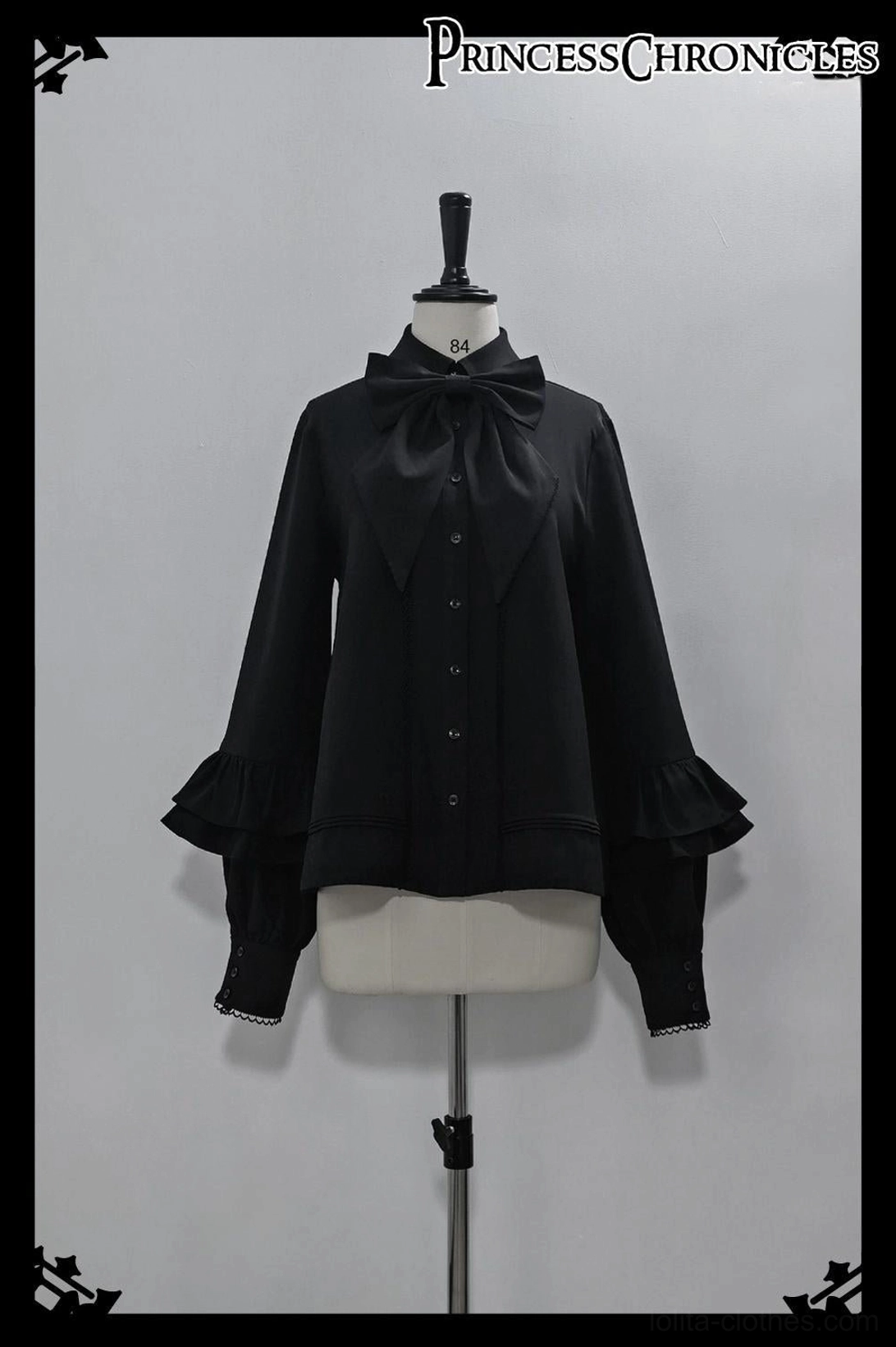 Black Ouji Lolita shirt front view on mannequin featuring detachable large bow tie, flared bishop sleeves with tiered ruffles, front button placket, and matte smooth fabric perfect for prince lolita coordinates