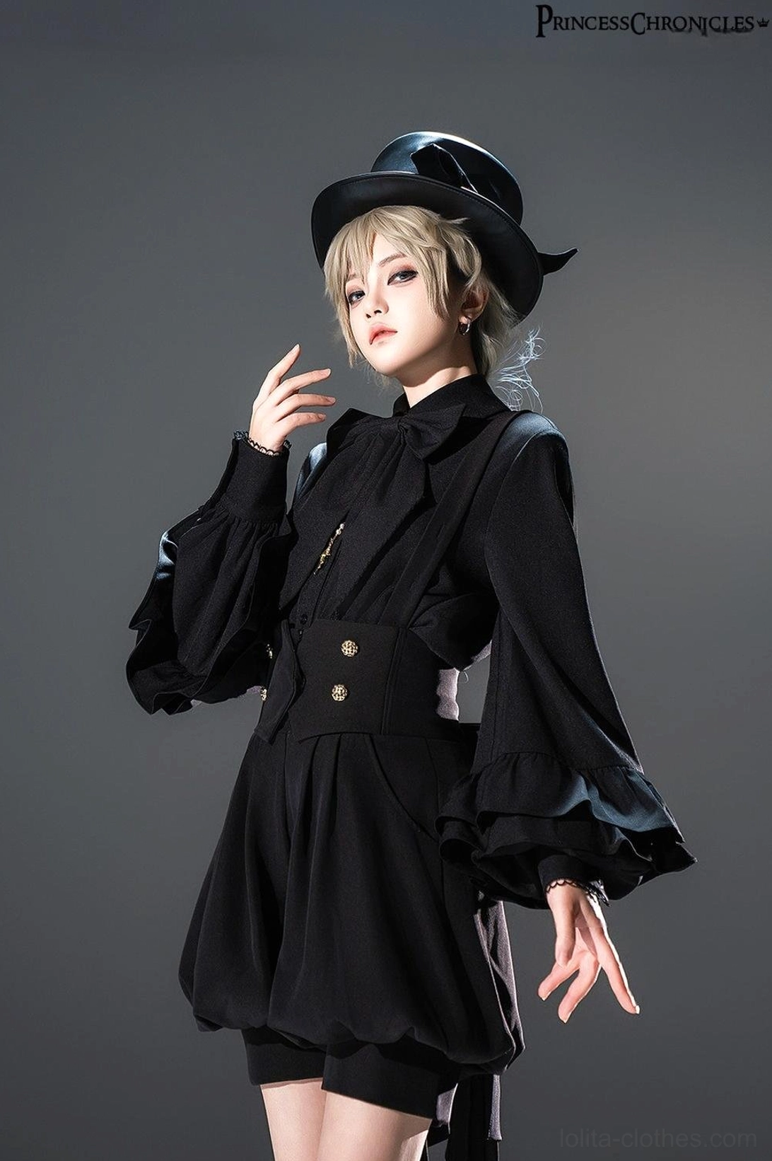 Model wearing black Ouji Lolita coordinate with detachable bow tie shirt, bishop sleeves, black top hat, and matching high-waisted shorts creating complete prince lolita aesthetic