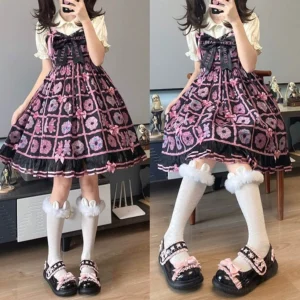Back three-quarter view of model wearing black patent leather Lolita Mary Jane flat shoes with pink bow and ruffle trim, star-shaped buckle straps paired with ruffled white socks
