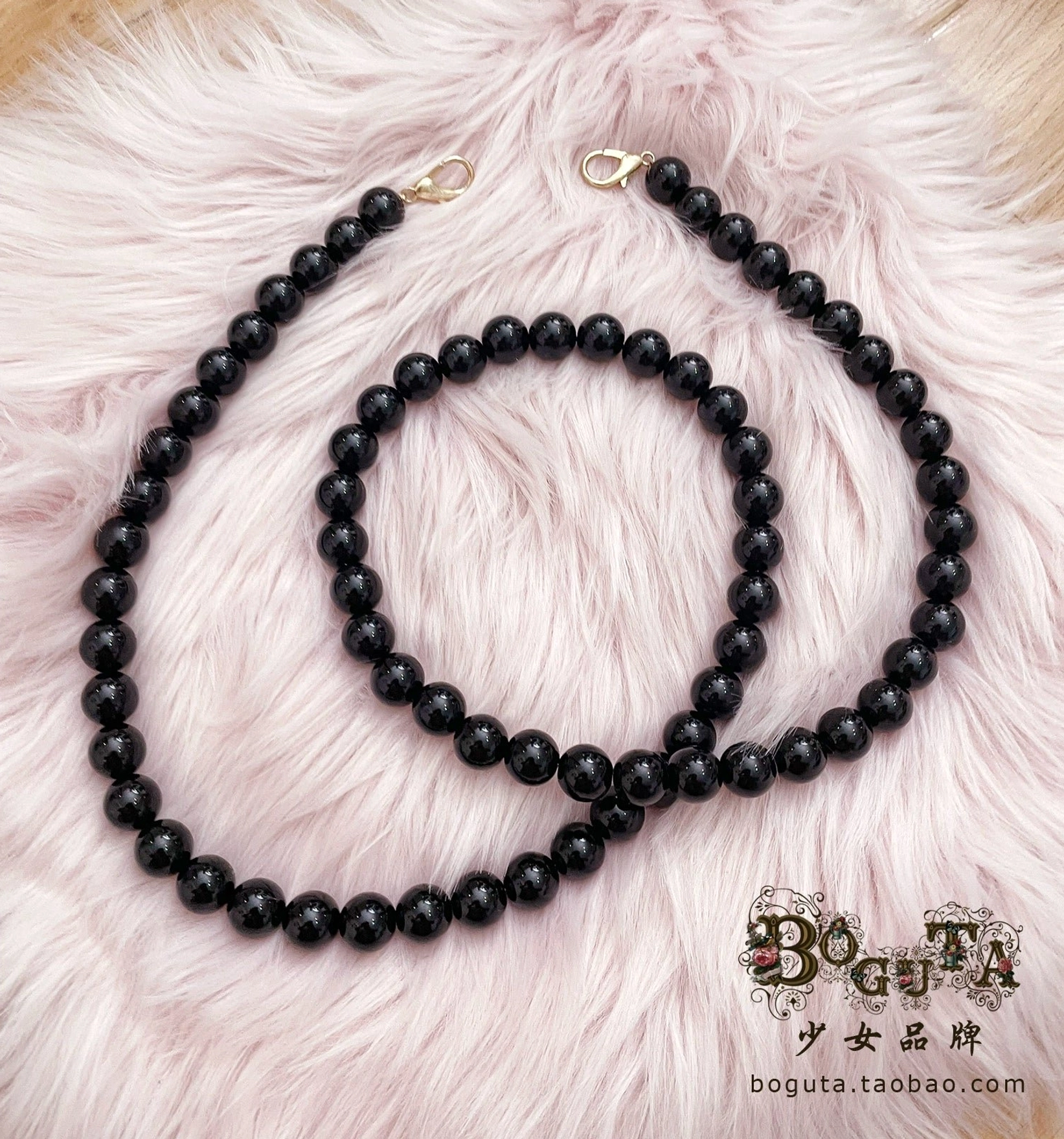 Black matte bead crossbody bag pearl chain strap 100cm length with glossy finish beads and gold lobster clasps perfect for lolita conventions and shopping on pink background