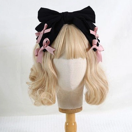 Black bowknot lolita hair headband with four pink satin bow decorations on blonde mannequin head front view lolita fashion accessory