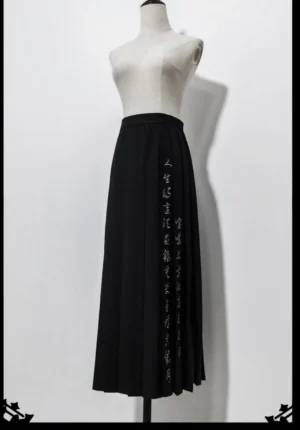 Black pleated Qi Lolita Ouji skirt with side Chinese calligraphy embroidery, front view on dress form showing knife pleats and concealed waist button