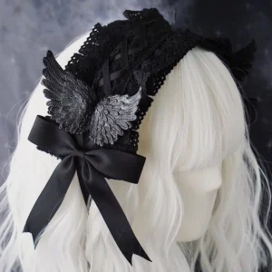 Black gothic raven wing lolita hairband with large satin bow and silver-black wing ornaments displayed on white mannequin head showing crossover strap design
