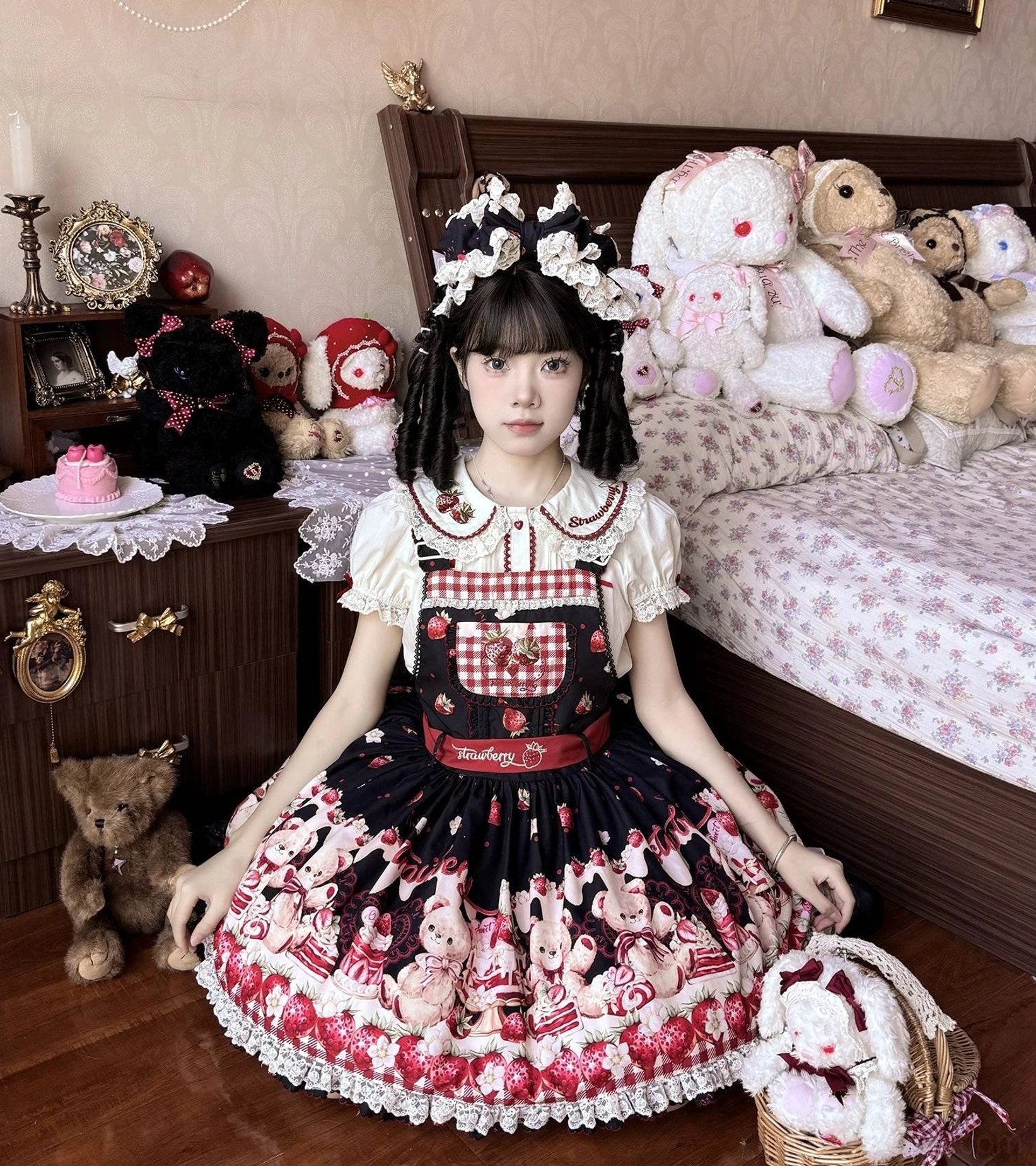Black-red colorway sweet lolita salopette with gingham chest panel, embroidered strawberry accents, ruffled lace hem, sitting in vintage bedroom with floral hair accessories