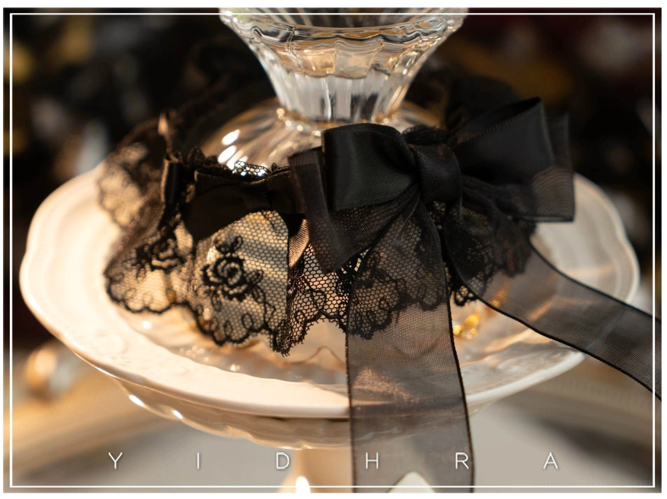 Black removable Lolita sock cover with floral lace trim and large sheer black satin bow decoration gothic style accessory flat lay on tabletop