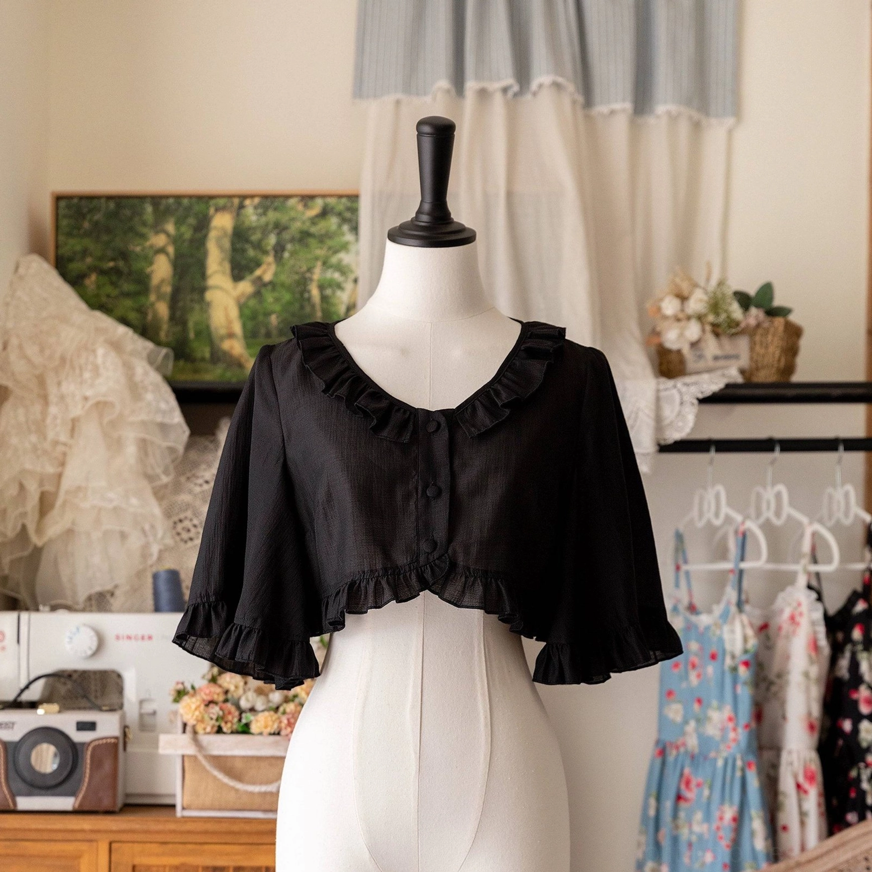 Black ruffled cropped cardigan rear view on dress form, clean back design with full ruffled trim, demonstrates how cropped length balances Lolita A-line dress silhouettes