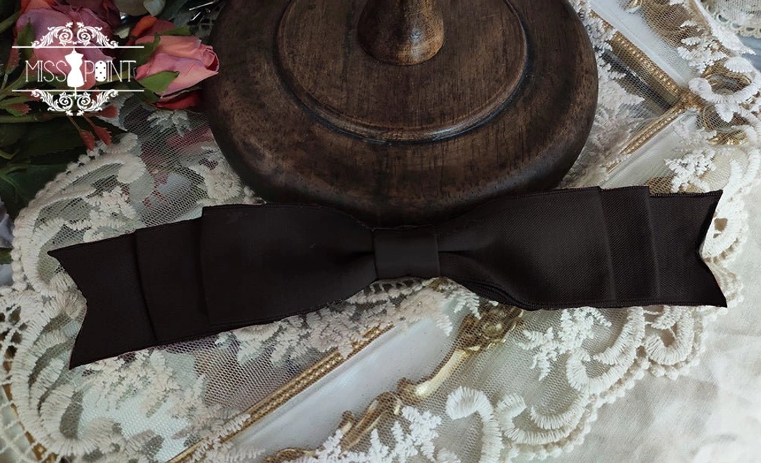 Black satin bow waist accessory for Classic and Gothic Lolita dresses shown with lace fabric and romantic rose decoration