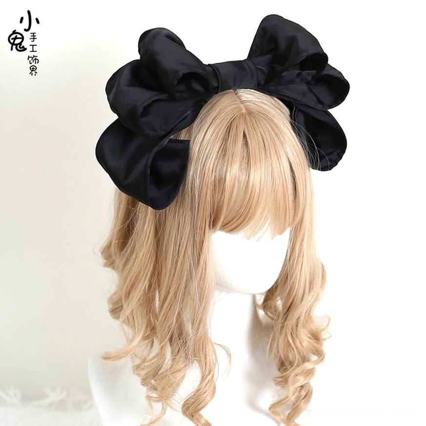 Classic black oversized satin bow Lolita hair clip frontal close-up on mannequin with blonde wig smooth satin fabric voluminous 3D layered bow
