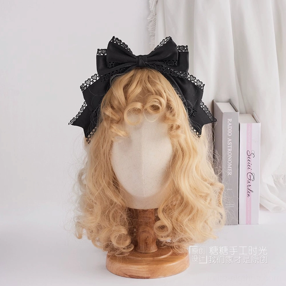 All black satin sweet lolita bow headdress with layered black lace trim frontal display on curly blonde wig mannequin