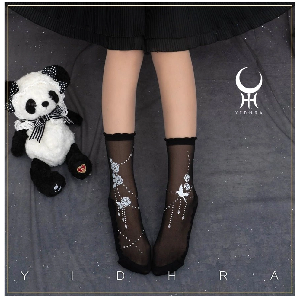 Black sheer Lolita ankle socks with plain ribbed cuff trim and floral bird printed patterns on sheer mesh with panda plush toy backdrop