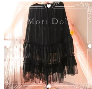 Black sheer tulle multi-layer ruffle lolita skirt with dark edge accents and gathered elastic waistline hanging on clothing rack display