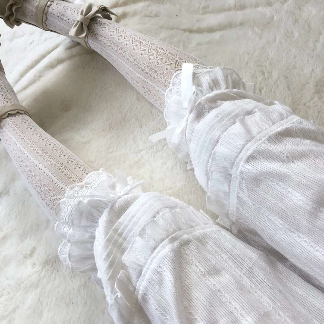 Black sweet lolita bloomers with accordion pleats lace edging and decorative satin bows flat lay display on soft plush background elegant design showcase