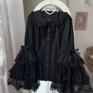 Black Sweet Lolita blouse with delicate Peter Pan collar lace trim and ruffled lace trumpet sleeves with bow cuffs, elegant hanging display on white background