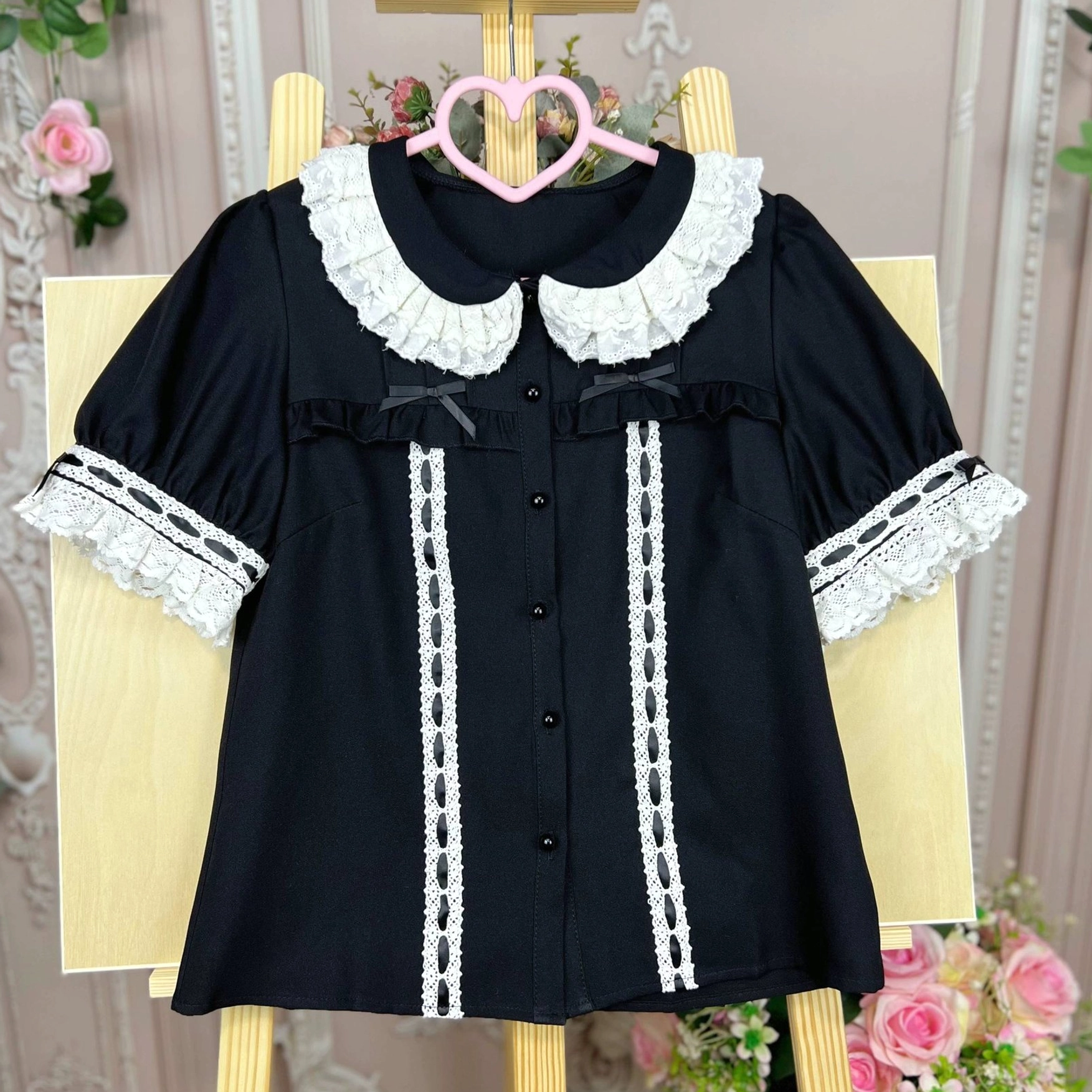 Black sweet lolita doll collar blouse displayed on mannequin showing gothic lolita styling option with architectural collar design and lace trim details against vintage backdrop