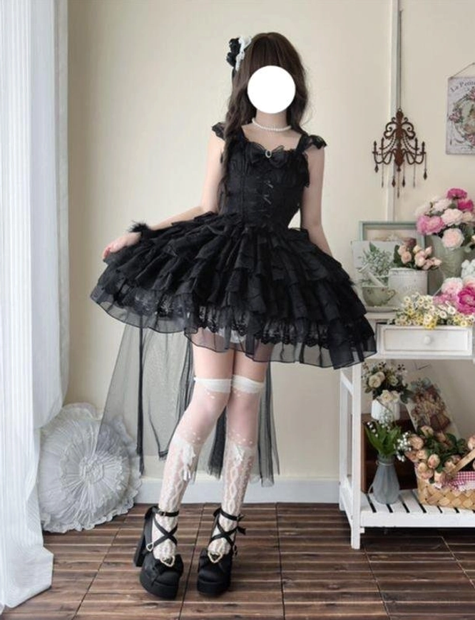 Black sweet lolita JSK with ruffled shoulders, back bow decoration, and sheer tulle trailing overlay, side three-quarter back view