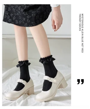 Black Sweet Lolita mid-calf socks with solid twisted knit texture and ruffled lace ankle trim paired with white Mary Jane heel shoes