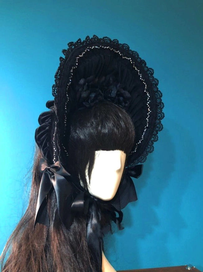 Black velvet gothic lolita bonnet left side profile showing gathered velvet crown, delicate beaded lace brim trim and satin chin bow detail