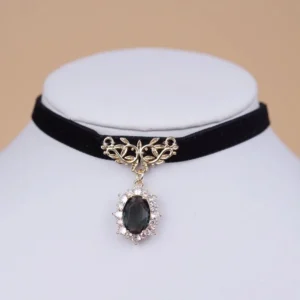 Black velvet Victorian lolita choker with ornate gold floral clasp and oval black rhinestone gem pendant displayed on white mannequin neck front view close-up