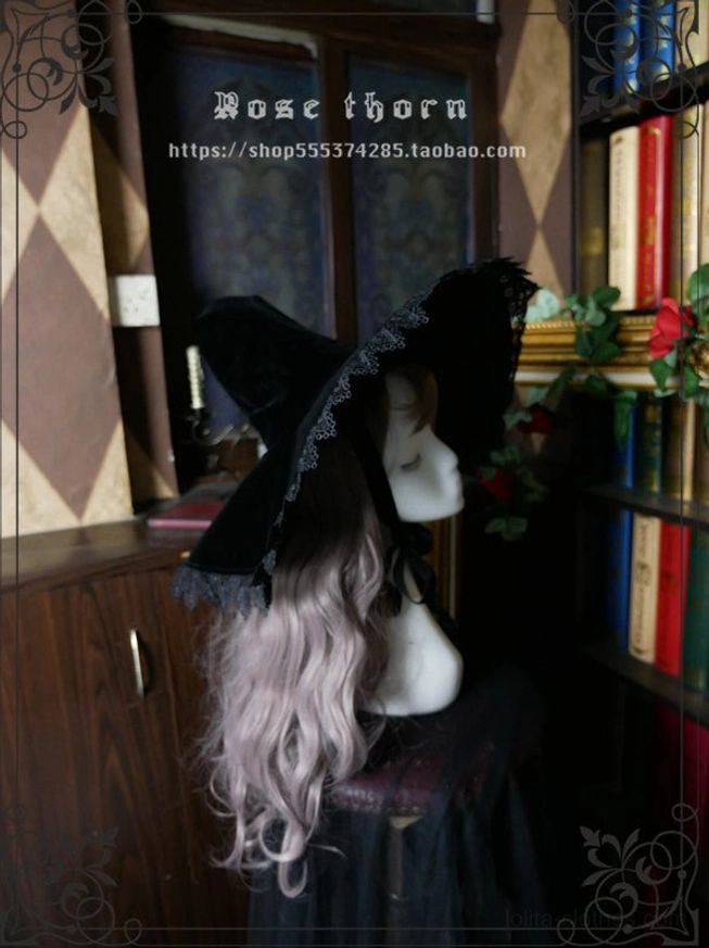 Black velvet pointed witch hat styled as part of complete lolita gothic coordinate, showing how headdress pairs with dark fantasy aesthetic and formal lolita fashion elements
