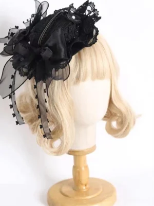black vintage lace tea party top hat with organza bow and beaded tassels side view on blonde mannequin lolita headdress