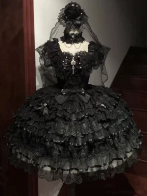 Black wedding lolita JSK dress with sweetheart neckline, tiered ruffled tulle skirt, short puff sleeves, and crystal pendant bow decoration displayed on dress form