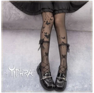 Black wedding night butterfly lolita summer tights with 3D bow and lace calf detail worn with black leather loafers and ruffled skirt, front low-angle view