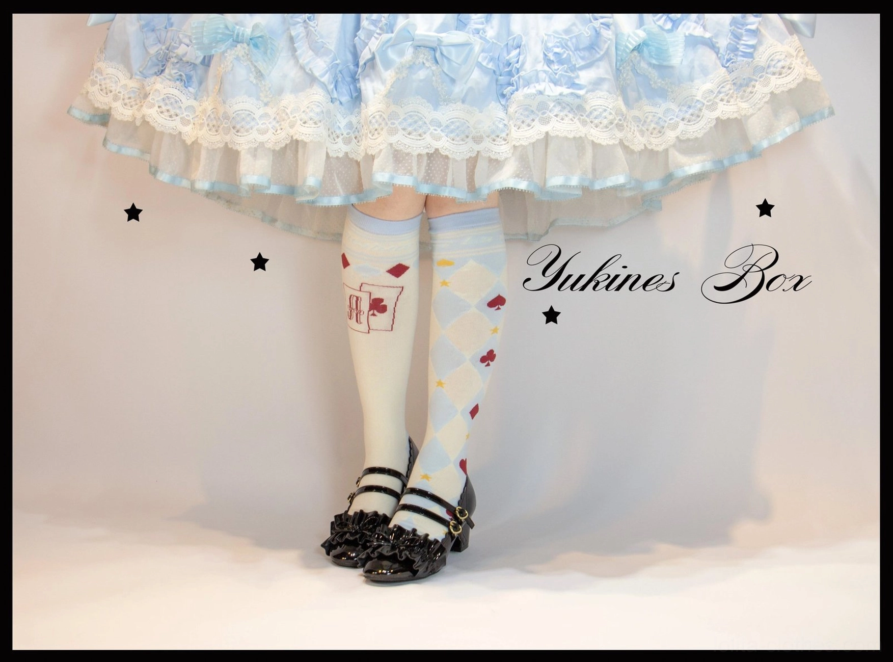 Black and white asymmetrical poker lolita socks styled with classic maid dress and vintage accessories coordinate flat lay styling