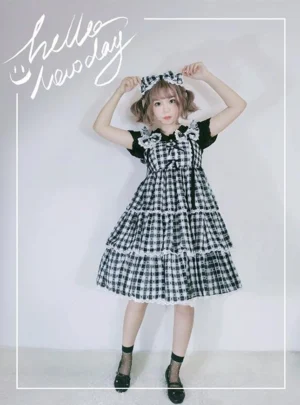 Black and white gingham sweet Lolita jumper dress JSK with tiered ruffle lace hem, matching headbow and front bust bows in full-body front view