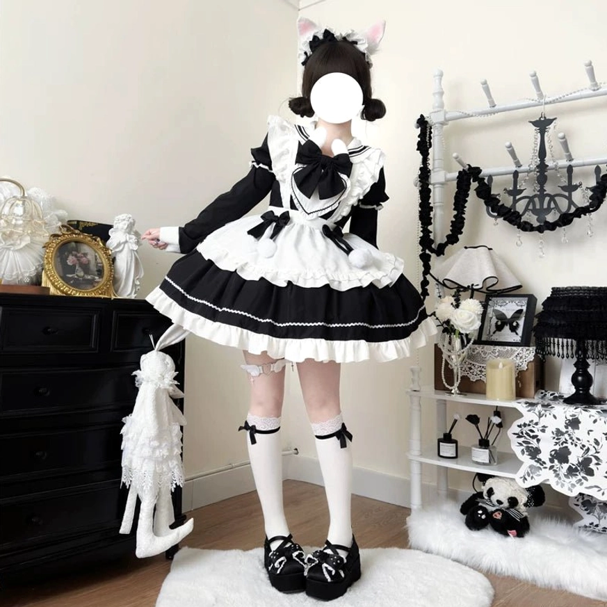 Model in cat ear hairpin wearing black and white maid lolita dress with contrast color blocking, front big bow, tiered ruffles, white stockings and black Mary Jane shoes, full-body front view