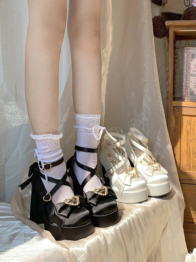 Black and white Sweet Lolita Mary Jane platform heels on model legs low angle indoor wooden cabinet backdrop glossy satin finish