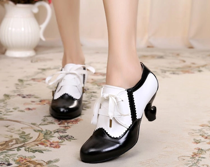 Black and white retro two-tone Sweet Lolita high heel Mary Jane shoes with scalloped stitching trim and curved spool heel, shown worn on feet with ribbon lace closures visible