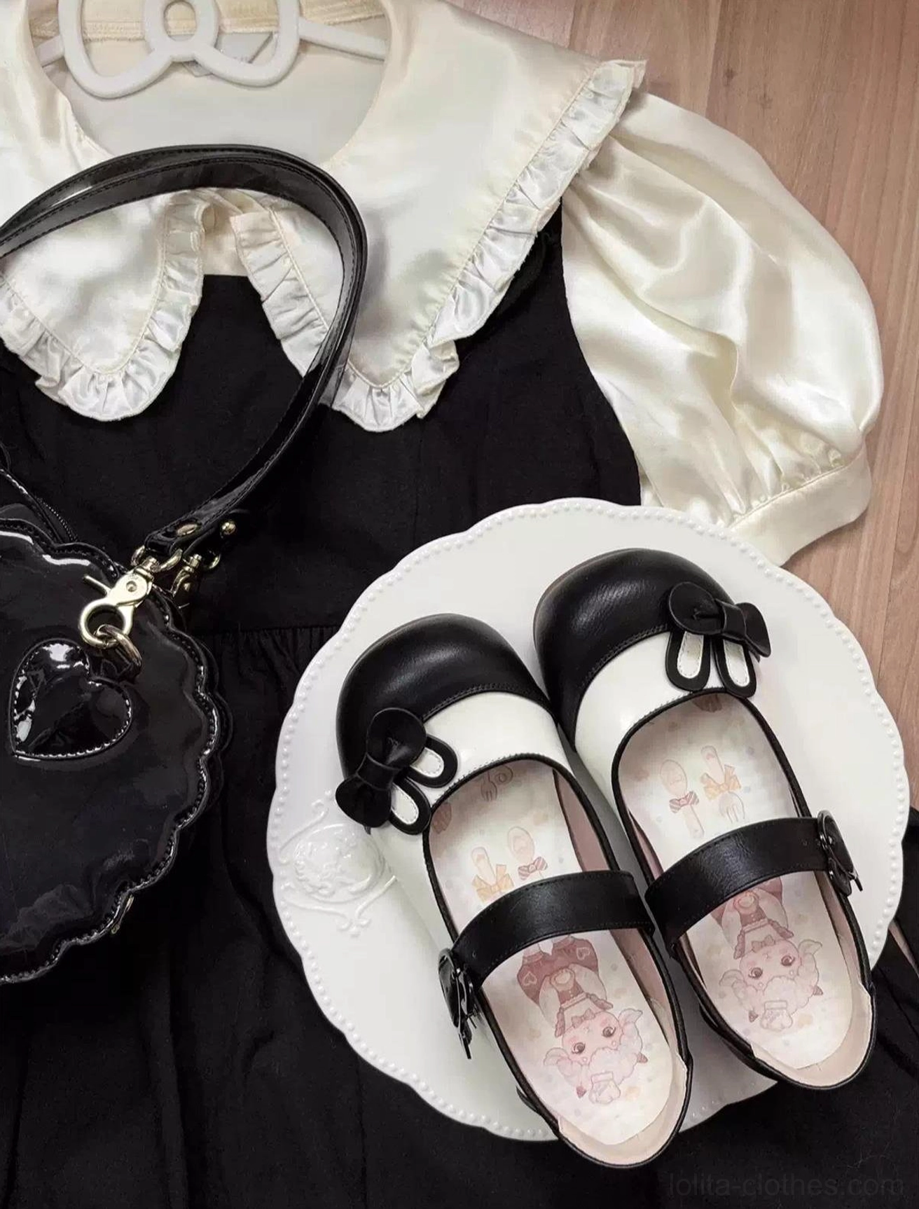 Black and white two-tone lolita Mary Jane shoes worn with black lolita dress and heart-shaped handbag showing classic color-block design and bow vamp decoration