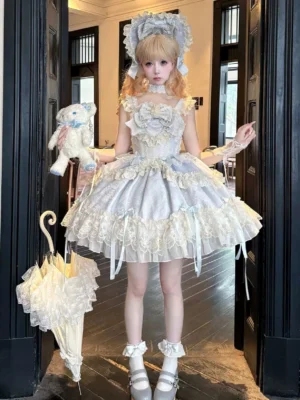 Blooming ballet sweet lolita JSK dress full-body front view silvery white with cream lace ruffles bows and multi-layered skirt worn with blonde twin bun bonnet white gloves ruffled socks Mary Jane shoes holding teddy bear and vintage lace umbrella