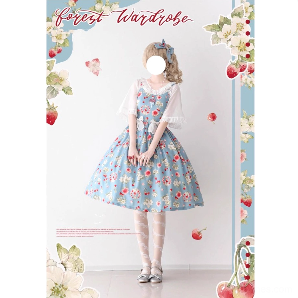 Model wearing berry blue floral print Lolita suspender dress with matching white ruffled cropped cardigan, square neckline, A-line midi skirt, strawberry themed promotional background