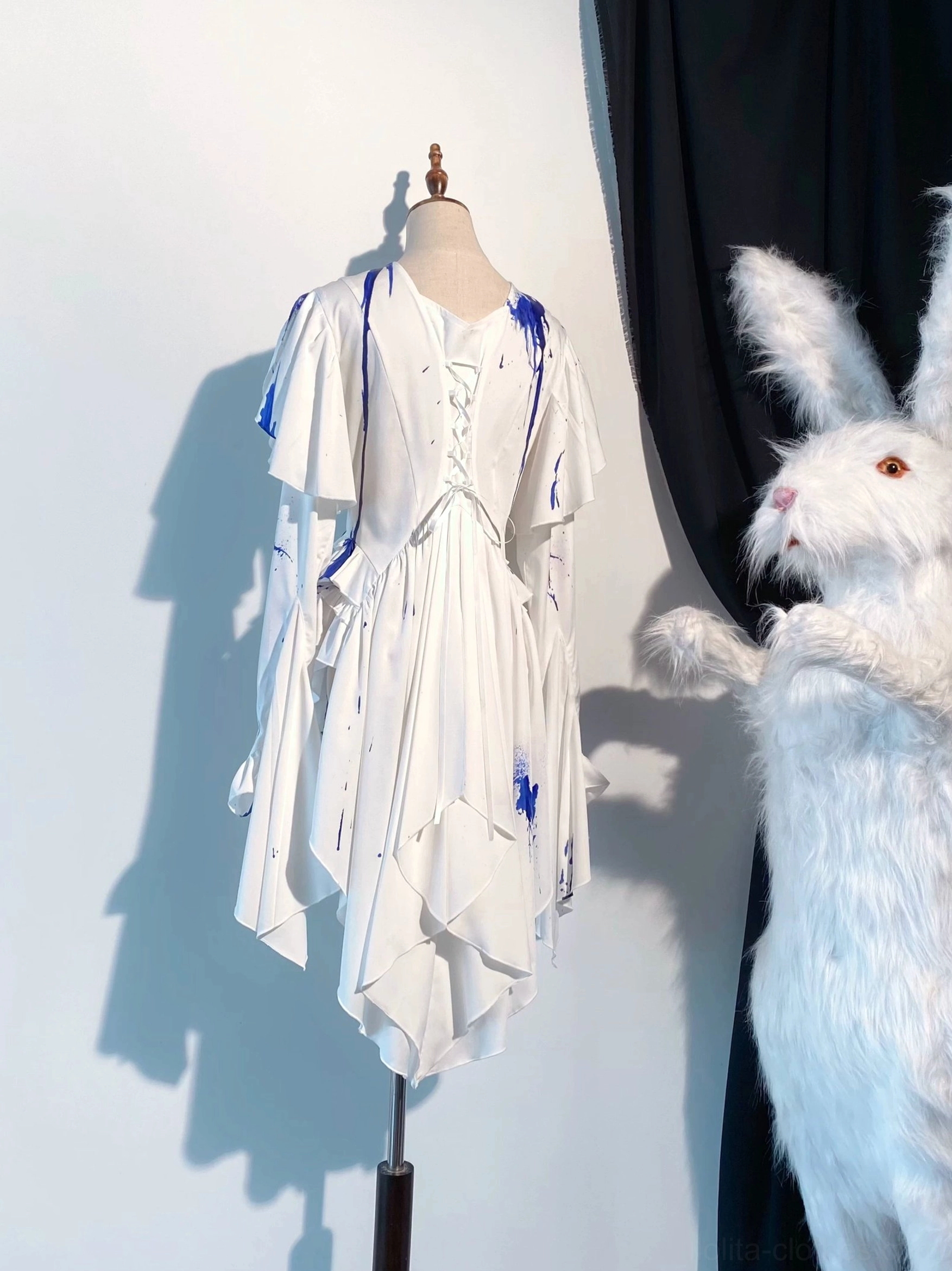 Blue blood-stain Ouji lolita dress set displayed on mannequin in three-quarter view, featuring ocean-inspired splash prints, front lace-up corset detail, and dramatic ruffled asymmetrical skirt silhouette