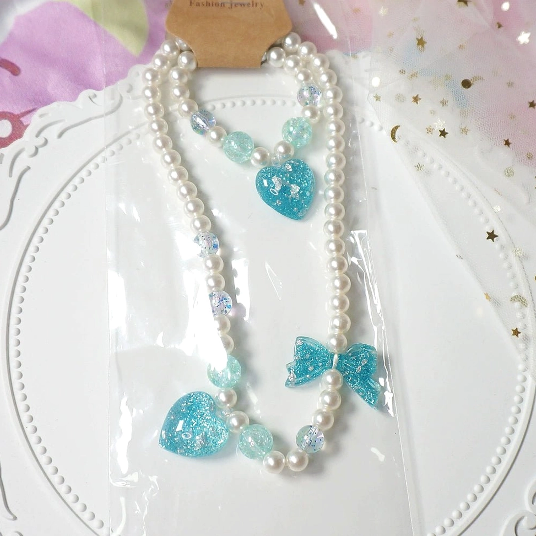 Blue heart charm gradient pearl choker and matching bracelet lolita accessory set on decorative white lace tray