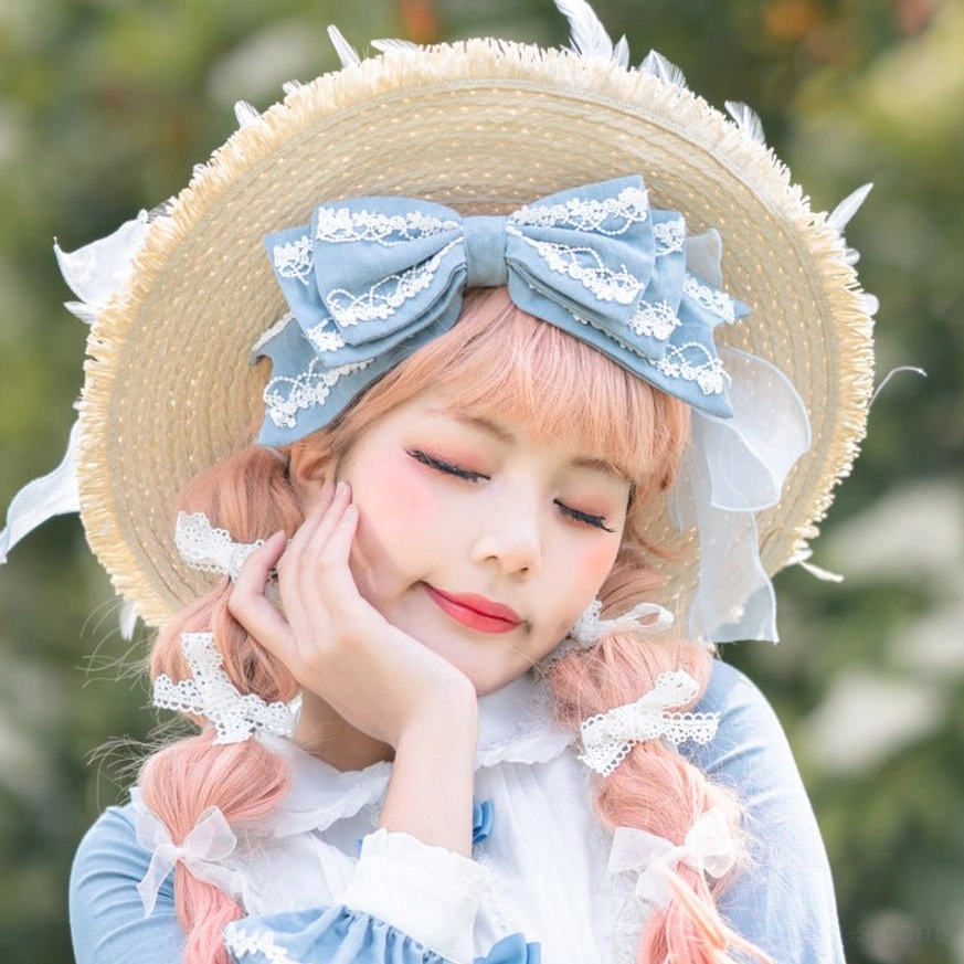 Blue lolita bow KC headband with white lace on model wearing straw hat and maid dress