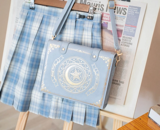 Blue magic book lolita crossbody clamshell bag with structured book silhouette and gold foil celestial pattern design