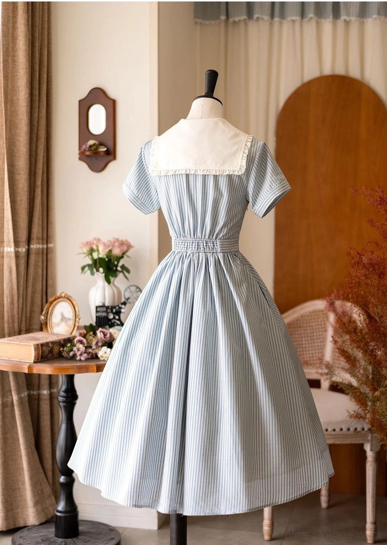 Back full-body view of blue striped classic Lolita OP dress showing elasticated back waist, white sailor collar, and full flared midi skirt silhouette