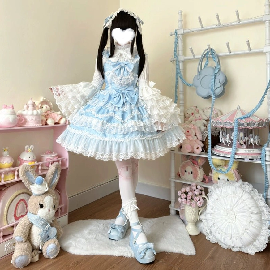 Blue sweet wedding lolita JSK dress full-body front standing view with tiered lace skirt and fitted waist satin bow in vintage doll display room