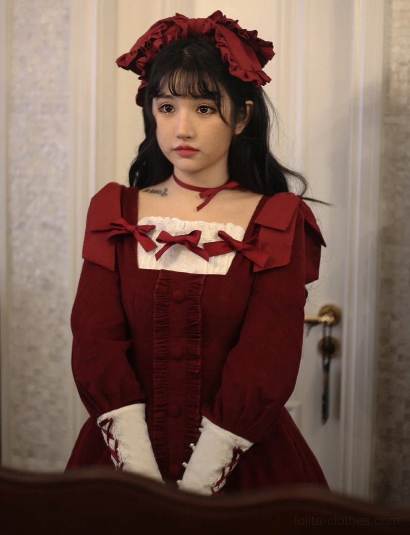 Blue velvet Lolita OP dress full-body model shot in vintage interior setting displaying corset lacing front panel system, structured waistline, and complete dress silhouette proportions
