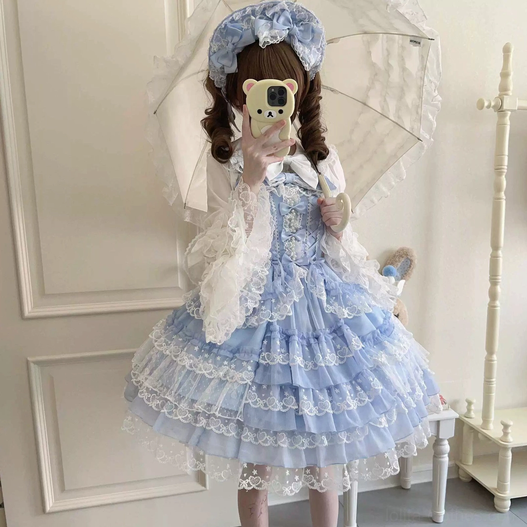 Blue and white ruffled Sweet Lolita dress with sheer lace sleeves, layered lace-trimmed skirts, and decorative ruffled collar with bow, styled selfie portrait