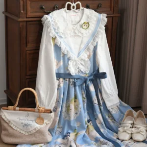 Blue and white vintage Lolita blouse and outfit coordinate with cartoon printed skirt, lace Peter Pan collar, puffed long sleeves, blue ribbon waist sash, displayed beside retro wooden dresser with bamboo handbag and white leather shoes